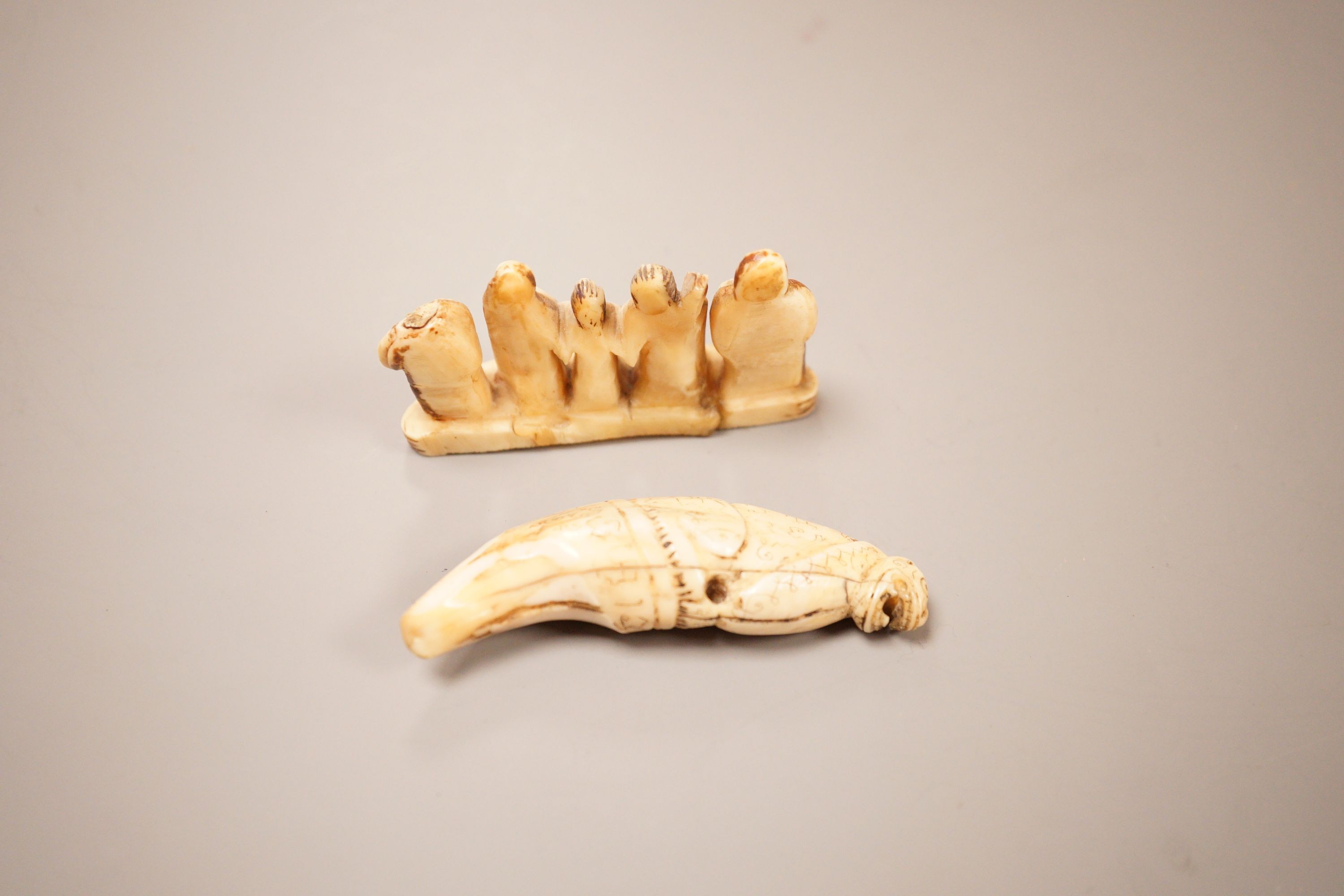 An Inuit whale tooth carving, 19th century, 8cm long, and a marine ivory religious group, possibly Goa
